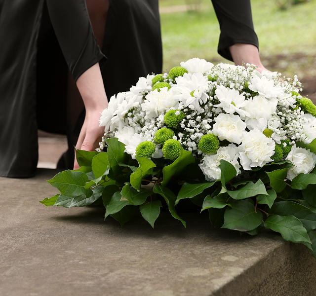 a woman laying down flowers